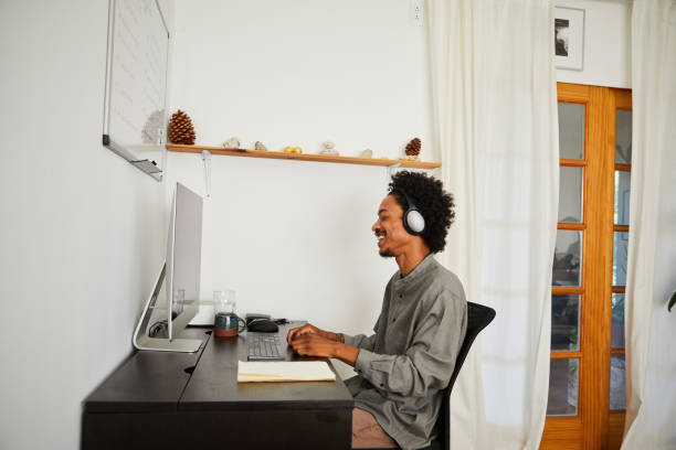 istock Young man laughing during an online call while working from home 1270255994