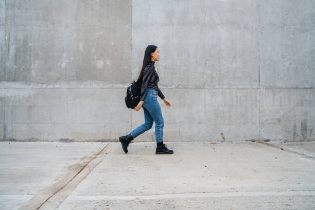 istock Asian woman walking against grey wall. 1270258496