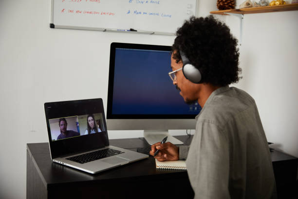 istock Young man video conferencing with colleagues from his home office 1270259833