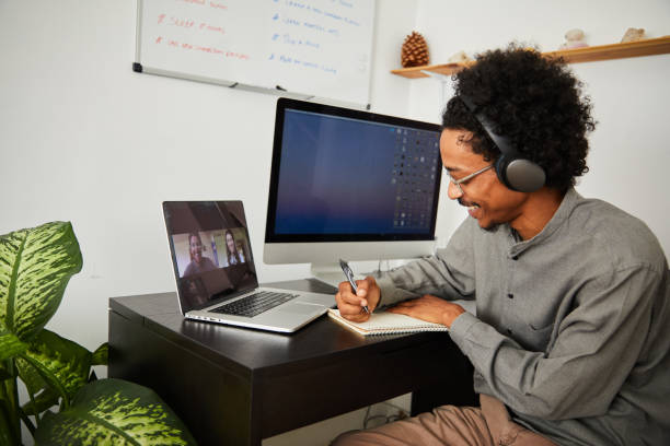 istock Smiling young man taking notes during a video conference call with work colleagues 1270260773