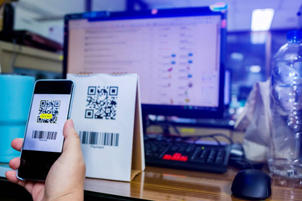 istock Selective focus to customer hand holding smart phone to scan Qr code payment and barcode with blurry online shopping website on computer screen. 1270261730