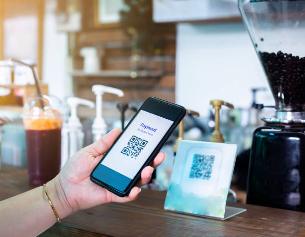 istock Customer hand using smart phone to scan Qr code payment tag  with blurry coffee grinder in coffee shop to accepted generate digital pay without money. 1270261758