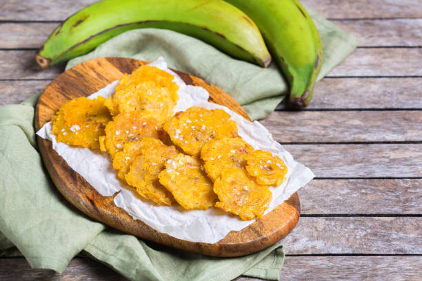 Fried tostones, green plantains, bananas with guacamole sauce stock photo