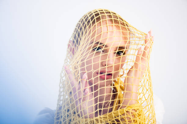 istock woman posing in yellow string bag on white background 1270263238
