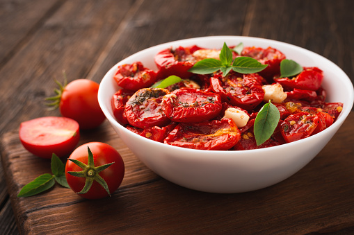Sun-dried tomatoes dressed with olive oil and spices in a bowl.