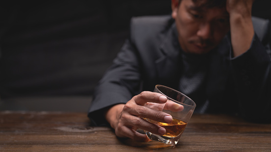 Close Up businessman holding a glass of whiskey.
Stressful concept