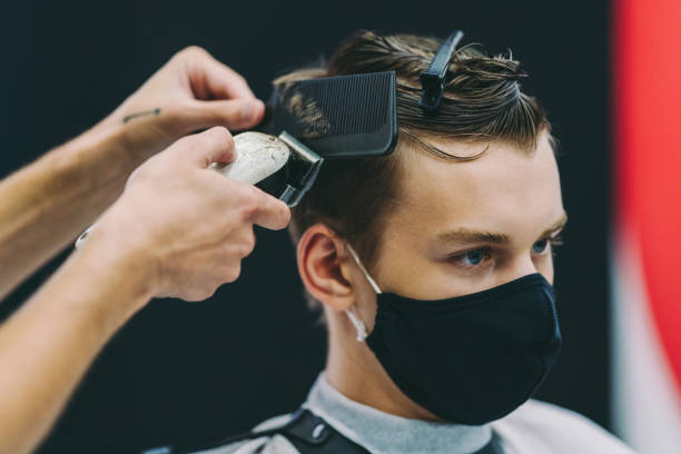 Back to school with new hairstyle, COVID-19 pandemic Student getting new haircut in the hair salon before going back to school teenager boy haircuts stock pictures, royalty-free photos & images
