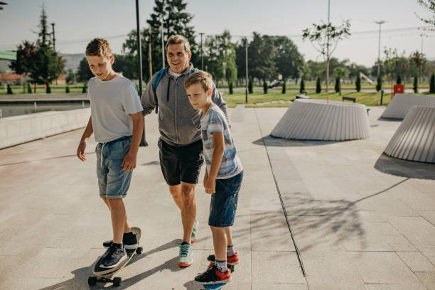 istock Senior man pushing grandsons on the skateboard 1270267519