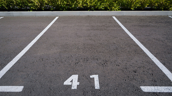 Close-up of a white paint number marking in a parking lot. Empty parking lot, Parking lot with white mark, Open parking in public park. Number 41