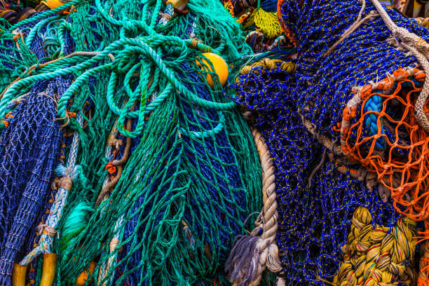 pile of rustic colorful fishing nets floats ropes - rede de arrastão imagens e fotografias de stock