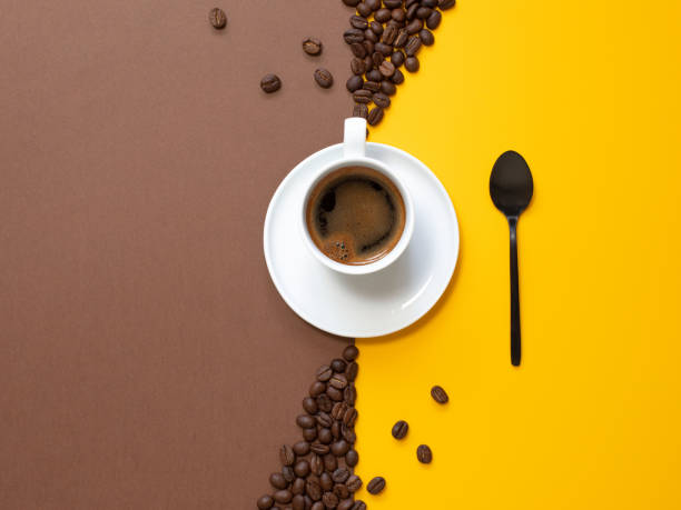 istock Cup of coffee with a spoon on  yellow-brown paper background. Copy space.. 1270270585