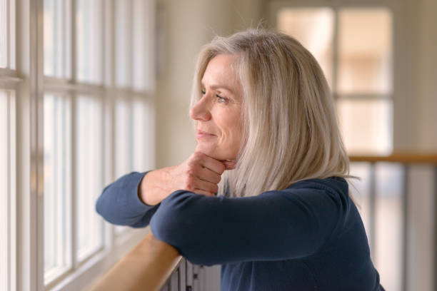istock Attractive blond woman watching through a window 1270271618
