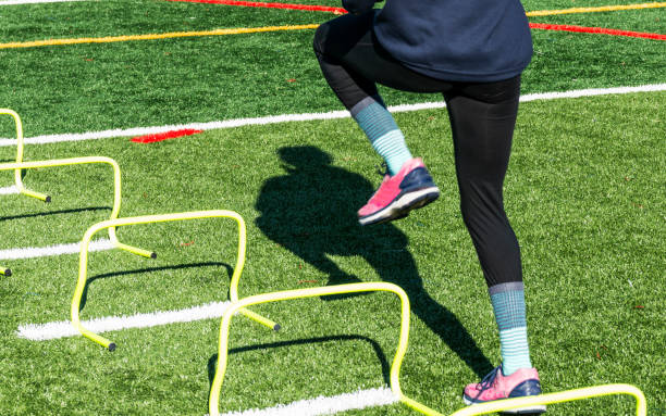 istock Athlete stepping over mini hurdles on a turf field 1270277333
