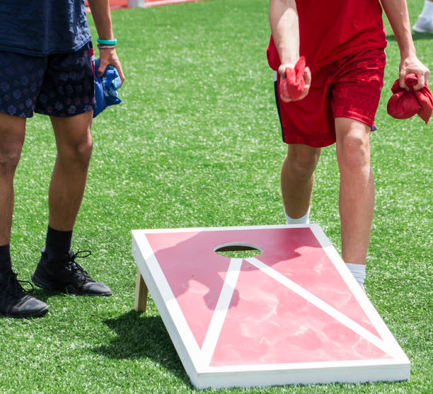 dwóch chłopców grających w otwór kukurydzy - cornhole leisure games outdoors color image zdjęcia i obrazy z banku zdjęć