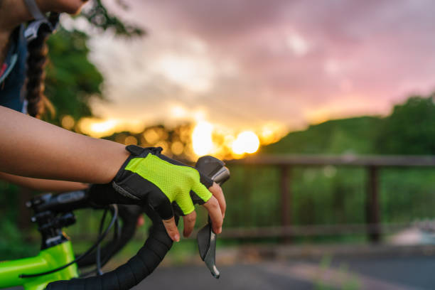 foto de close-up da mão de motociclista enquanto andava de bicicleta durante o pôr do sol - unrecognizable person sky athlete competitive sport - fotografias e filmes do acervo