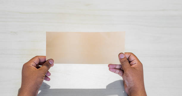 istock Hand of an Asian man holds blank envelop against white background. 1270281494