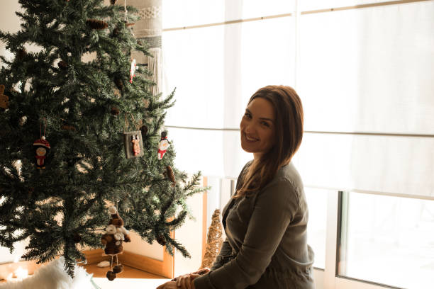 istock Woman decorating Christmas tree 1270284095