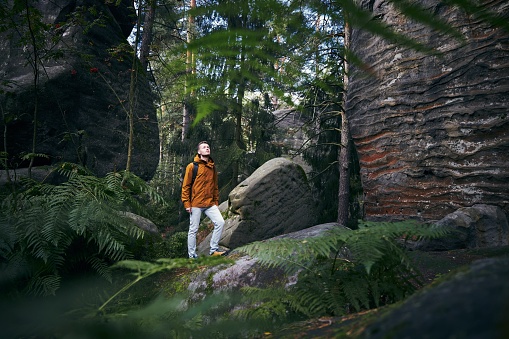 Youg man hiking in the middle of the rocks. Mala Skala in Bohemian Paradise, Czech Republic.