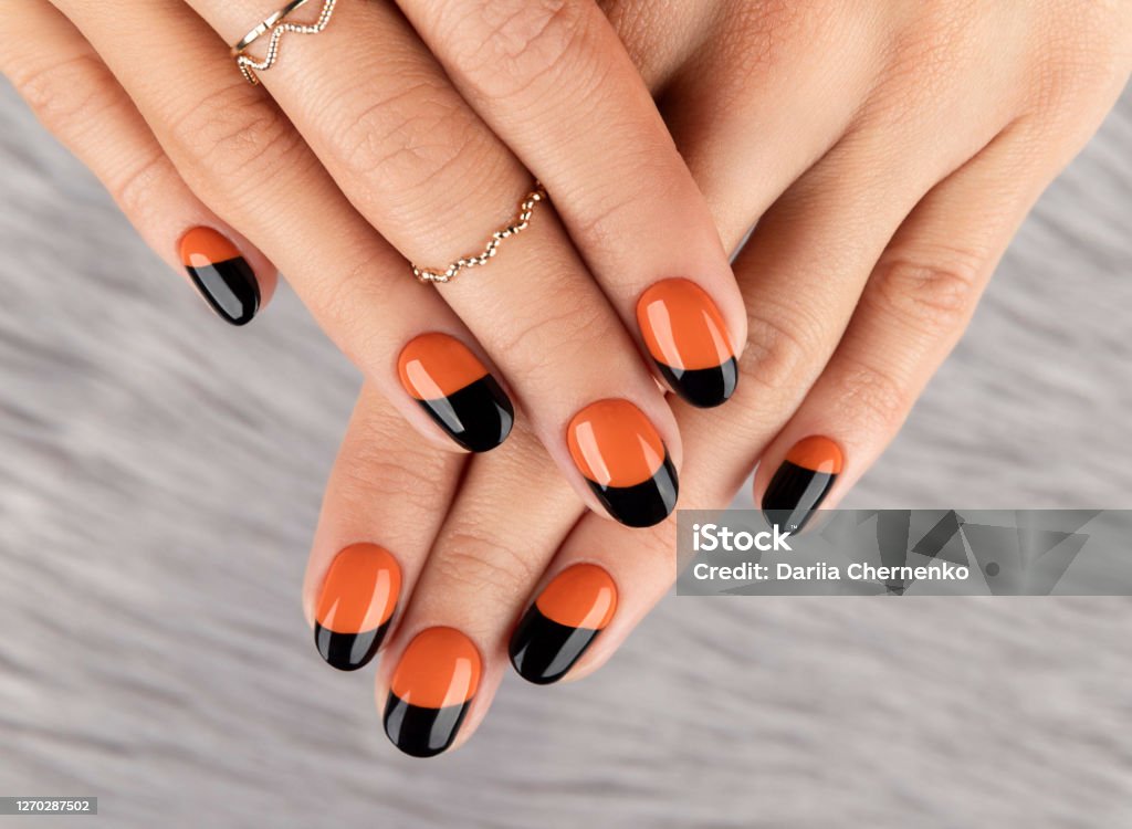 Manicured woman's hand over furry background. Manicured woman's hand over furry background. Trendy autumn halloween orange nail design. Nail Art Stock Photo