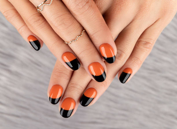 Manicured woman's hand over furry background. Manicured woman's hand over furry background. Trendy autumn halloween orange nail design. fall nail art stock pictures, royalty-free photos & images