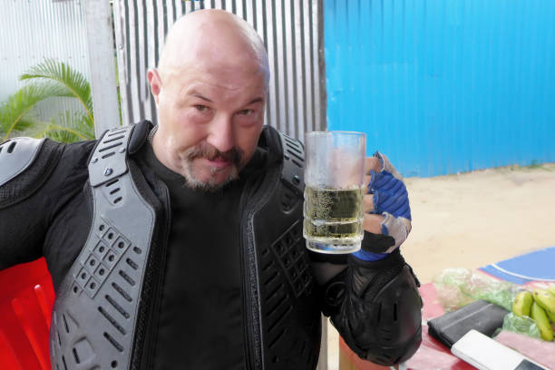 Serious man in motorcycle equipment with glass