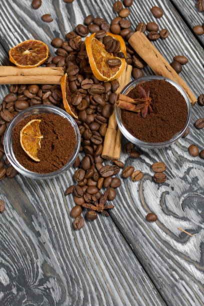 istock Coffee beans. Ground coffee in containers and spices. On a surface of brushed pine boards painted black and white. 1270293752