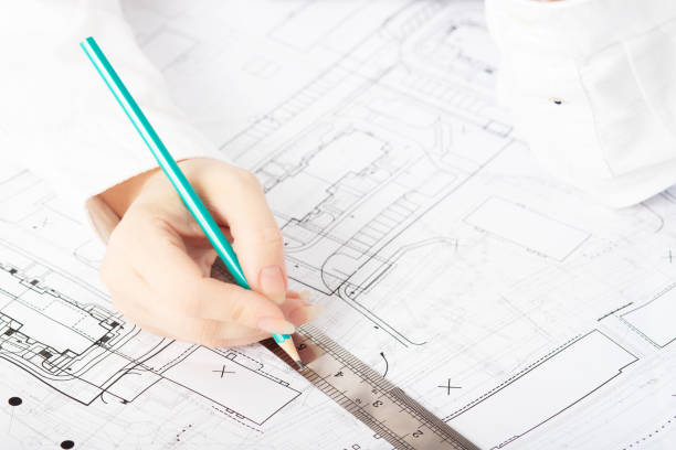 istock architect designer working on architectural blueprints, building plans in the office, drawing 1270294103