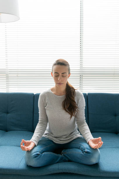 istock Young woman meditating at home 1270299757