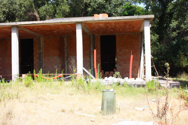 istock house under construction with exposed red bricks, concrete and supporting columns in architecture in a green pine forest of trees in tuscany 1270300207