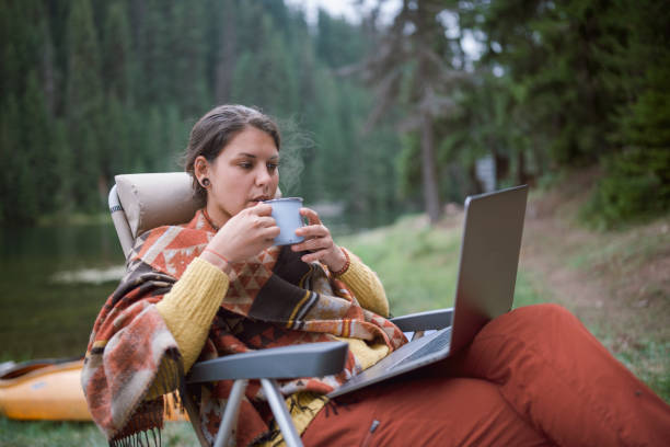 istock Young Beautiful Brunette is Working On Her Portable Computer While She is On A Camping 1270303819