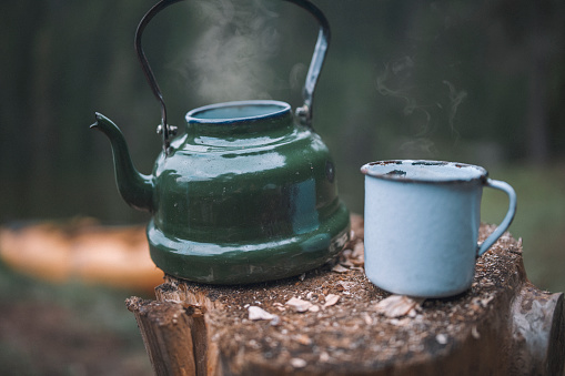 Vintage Boho Style Teapot And Metal Mug With Hot Smoke Coming Out Of Them