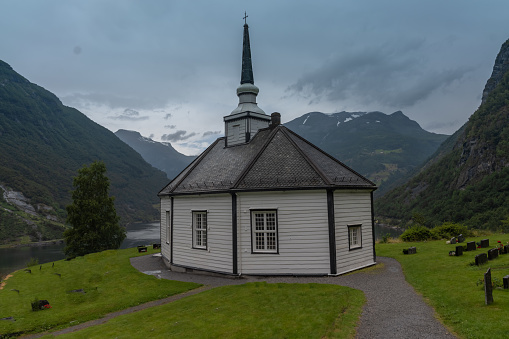 Geiranger Church, on a hill overlooking the Geiranger Fjord, Norway. The white, wooden church was built in an octagonal style in 1842.