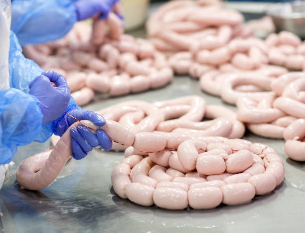 istock Butchers processing sausages at a meat factory 1270307368