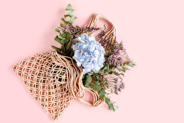 istock Beautiful bouquet of hydrangeas in a string, eco bag on white background. Flat lay, top view 1270309523