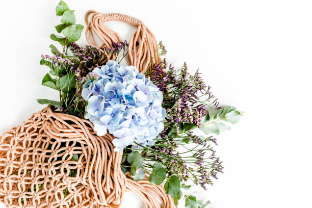 istock Beautiful bouquet of hydrangeas in a string, eco bag on white background. Flat lay, top view 1270309784