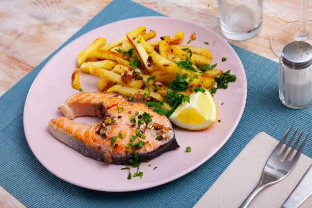 Photo of Tasty grilled salmon served with french fries