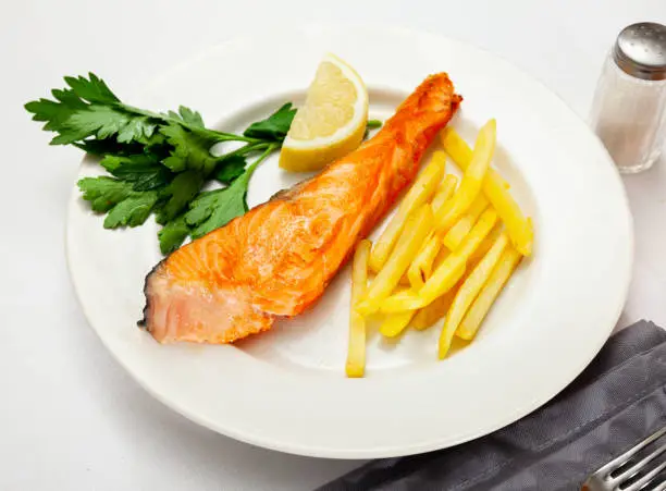 Photo of Tasty grilled salmon served with french fries