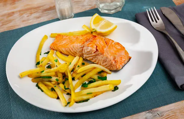 Photo of Tasty grilled salmon served with french fries