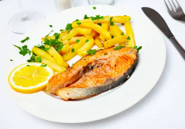 Photo of Tasty grilled salmon served with french fries