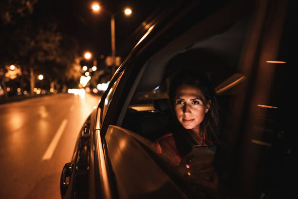 istock Beautiful woman sitting on back seat and looking through window at night 1270314291