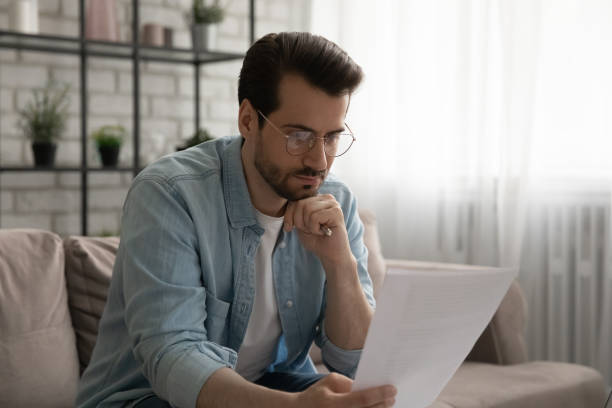 istock Serious man reading post paperwork letter at home 1270316200