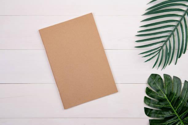 istock Blank cover book copy space with mockup and leaf on wooden table, poster and notebook, postcard decoration your design or branding, simplicity and minimal, nobody, flat lay, top view. 1270318554
