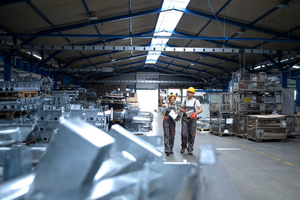 istock Factory workers walking through large industrial production plant and sharing ideas. 1270324780