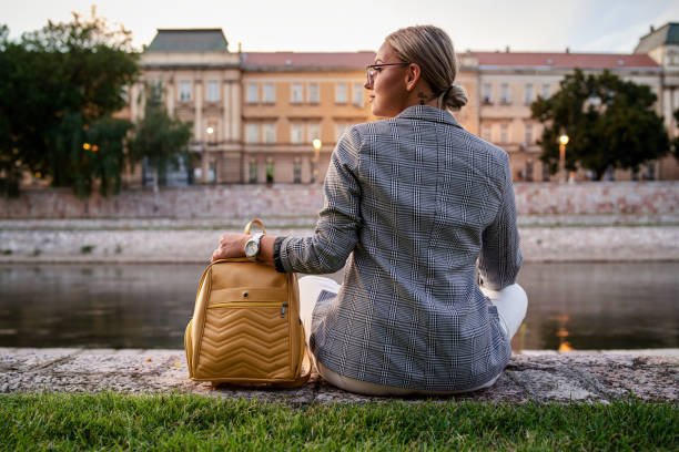 istock Young woman sitting outside with her back turned 1270328952