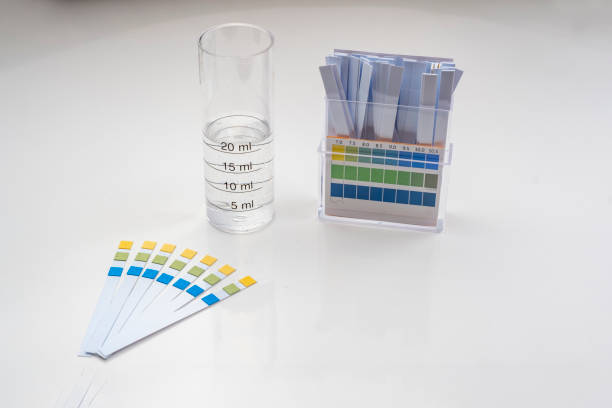 istock ph control strips, graduated cylinder with water and box of strips with color patterns 1270330102