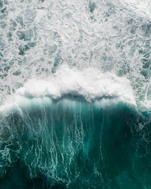 belle vue aérienne d’une vague s’écrasant dans un océan bleu pendant une tempête - wave surfing sea surf photos et images de collection