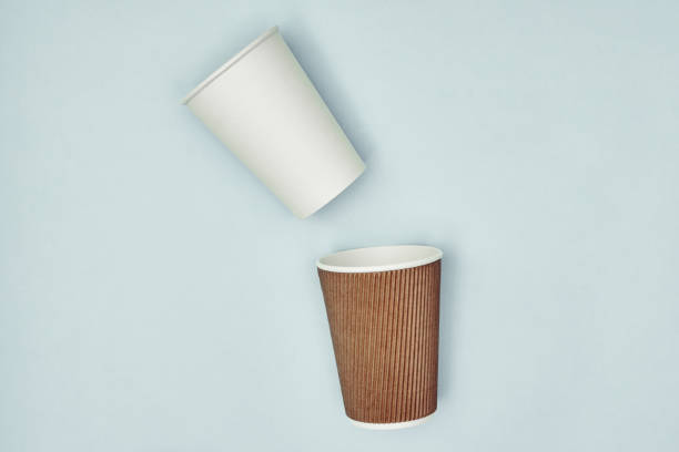 istock Paper cup in hand on a colored background. Eco-friendly materials in a coffee shop, biodegradable disposable tableware. Close up. 1270334319