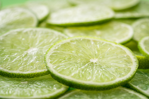 Lime fruits with green leaf and cut in half slice isolated on white background. Top view. Flat lay with copy space.