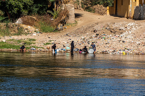 Near Luxor, Egypt, a group of local women are doing their laundry and washing dishes in the Nile river.