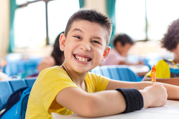 istock naughty school boy looking the camrea in classroom 1270337426